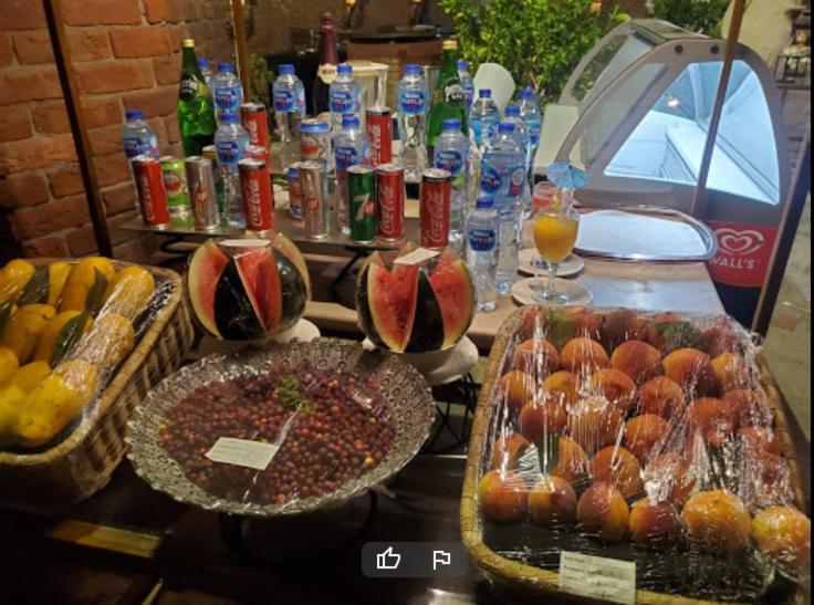 a table topped with baskets of fruit and drinks at Prime View Hotel in Faisalabad