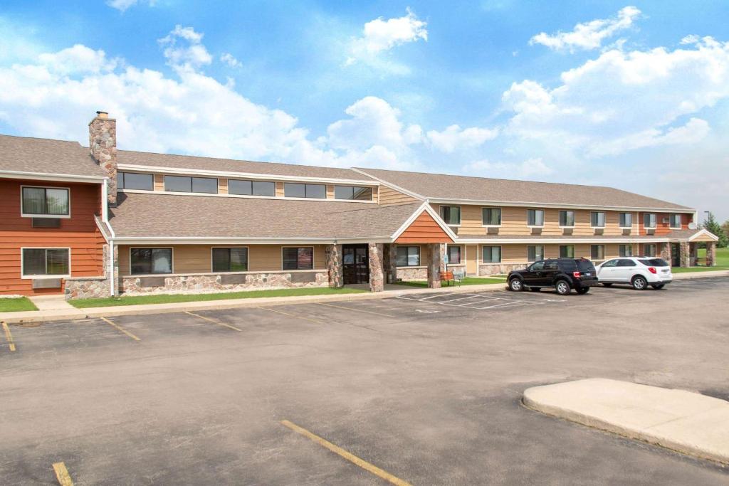 a parking lot in front of a large building at AmericInn by Wyndham Elkhorn Near Lake Geneva in Elkhorn