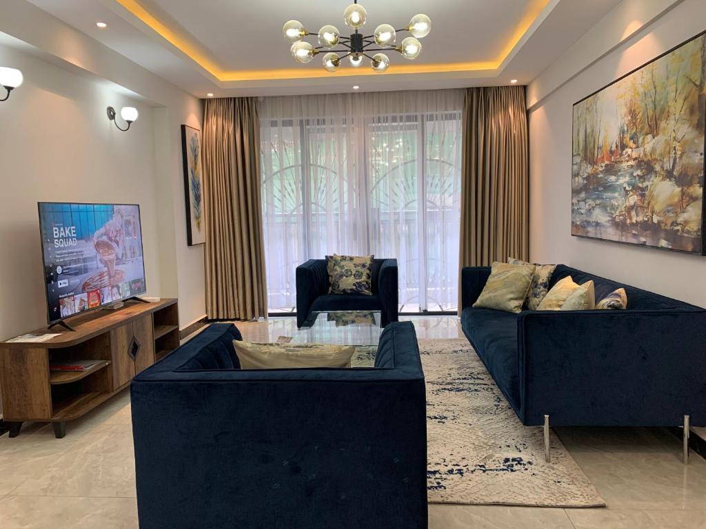 a living room with two blue couches and a television at Diamond Luxury Suite by Diamond Homes in Nairobi