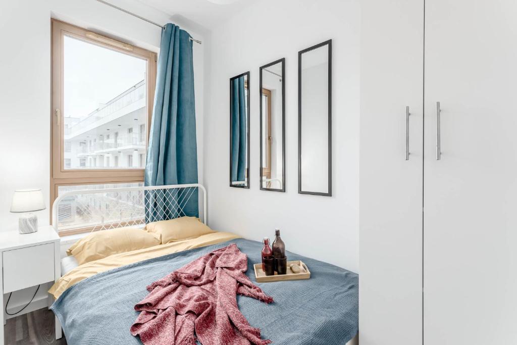 ein Schlafzimmer mit einem Bett mit einer rosa Decke darauf in der Unterkunft Chill Apartments Wilanów in Warschau