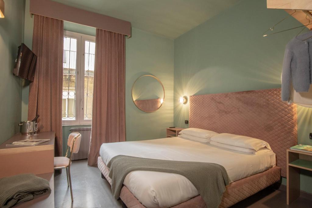 a bedroom with a large bed and a mirror at Hotel Milani in Rome