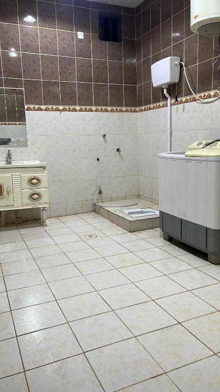 bagno con pavimento piastrellato, lavandino e vasca. di استراحات يمك دروبي a Madain Saleh