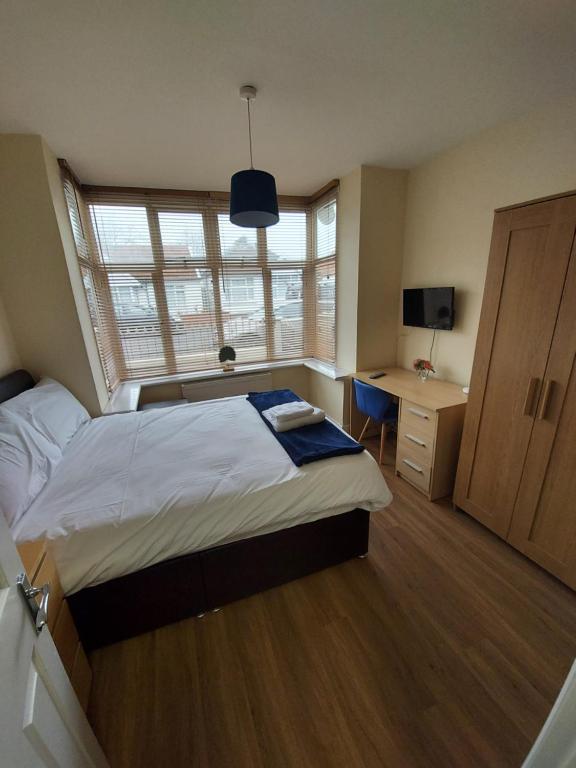 a bedroom with a bed and a desk and a window at BSL - Filton in Bristol