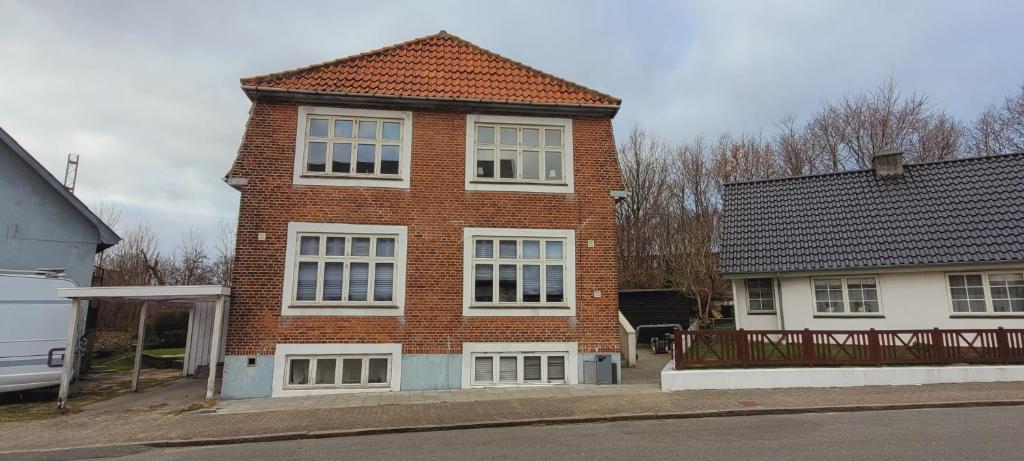 a red brick house with white windows on a street at Exnersgade 32. 1sal (id 035) in Esbjerg