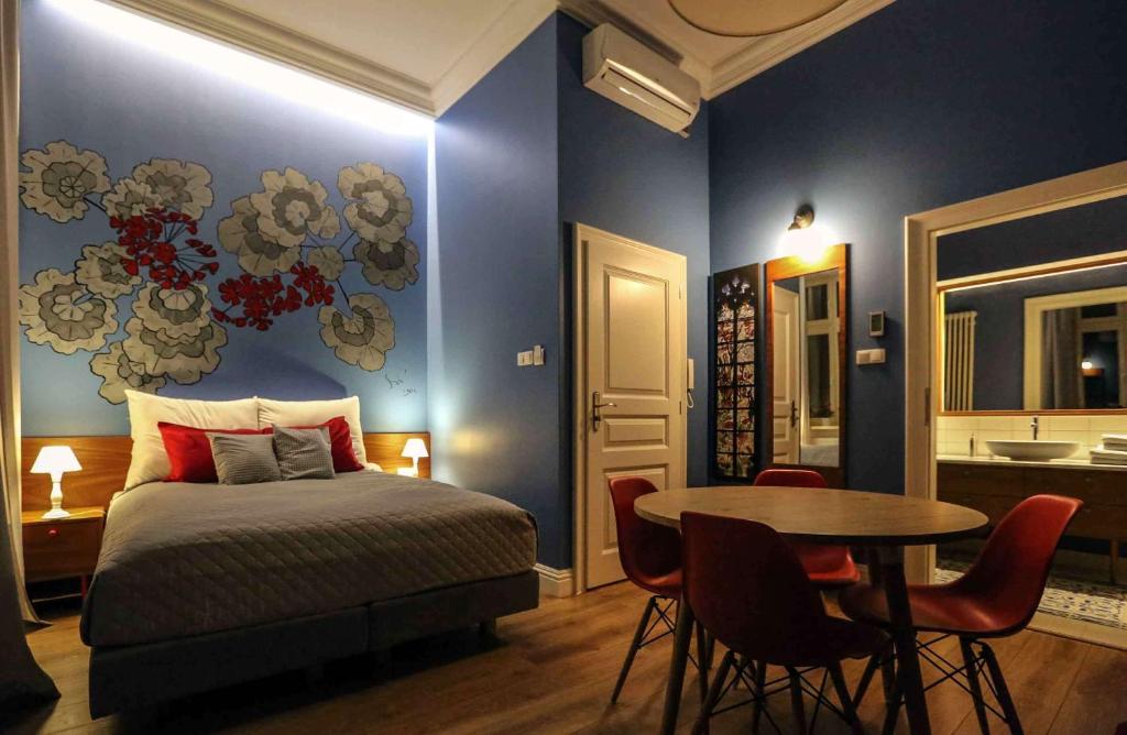 1 dormitorio con 1 cama y 1 mesa con sillas en Apartamenty Czapskich, en Cracovia