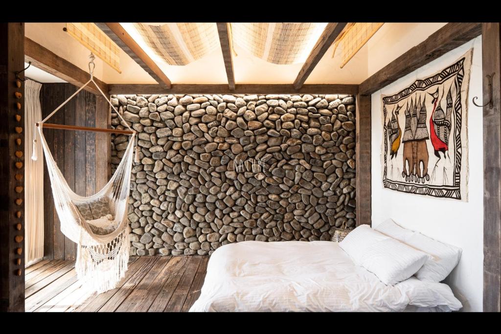 een slaapkamer met een bed en een rotswand bij on Le Su in Toucheng
