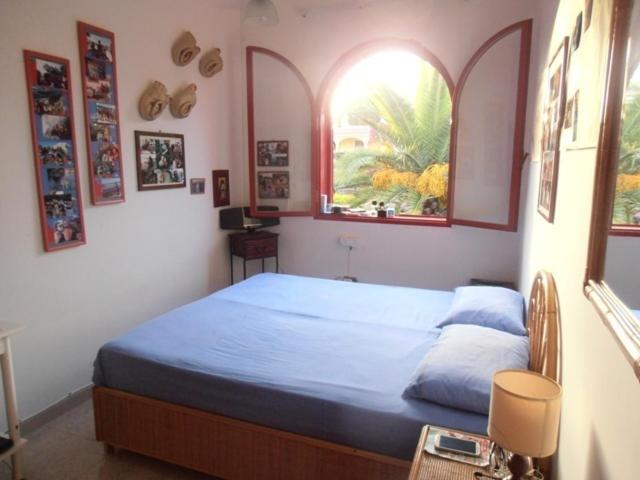 フォンターネ・ビアンケにあるVilla Morrealeのベッドルーム1室(青いシーツ付きのベッド1台、窓2つ付)