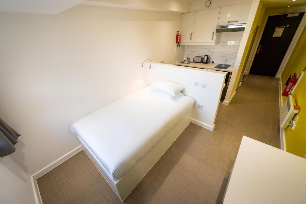 a small room with a white bed in a kitchen at University of Bath City Accommodation in Bath