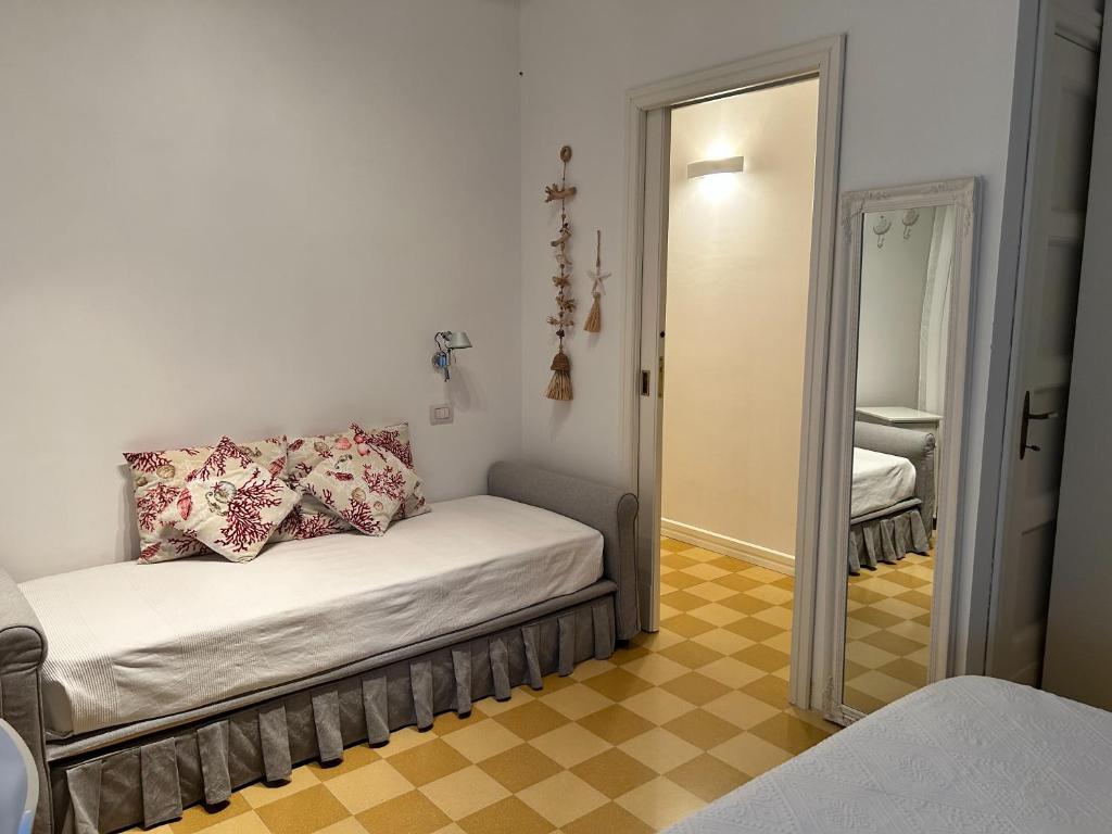 Cette petite chambre comprend un lit et un miroir. dans l'établissement SEABAUDIA1 CON TERRAZZA, à Sabaudia