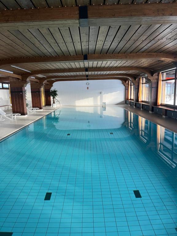 einen Innenpool mit blauen Fliesenböden und einer Holzdecke in der Unterkunft Apartment Annis Panoramablick Pool Sauna Tennis in Obertal