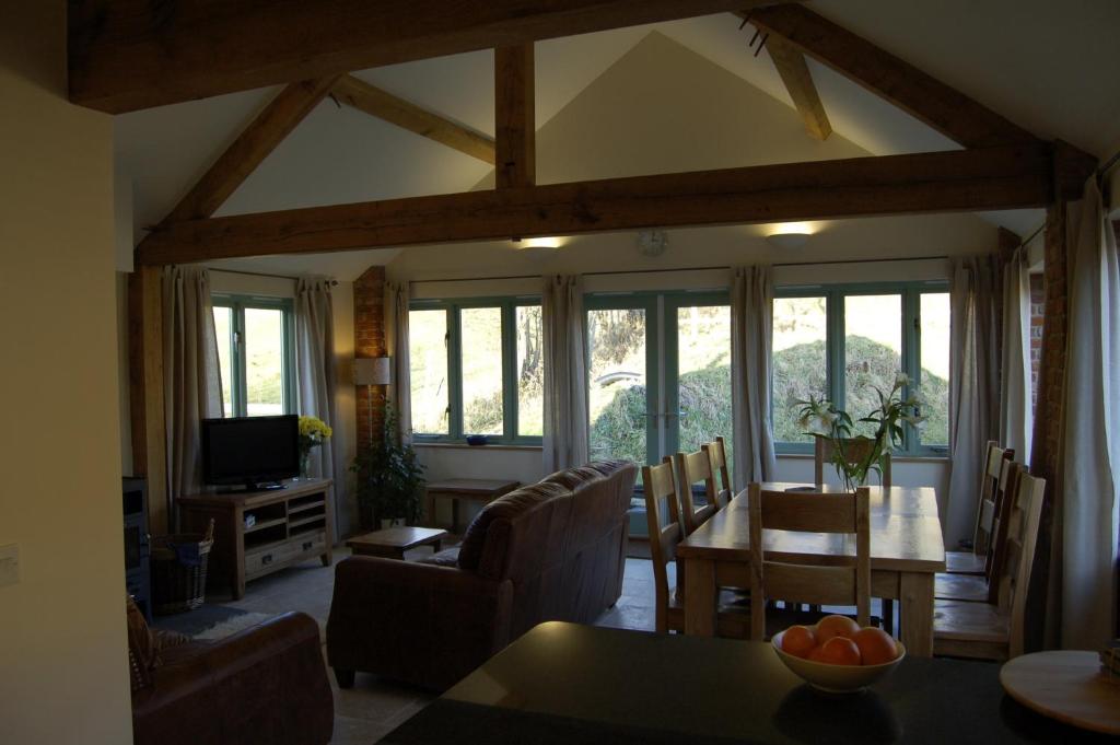 a living room with a table and a dining room at Honeysuckle Farm cottages in Glastonbury