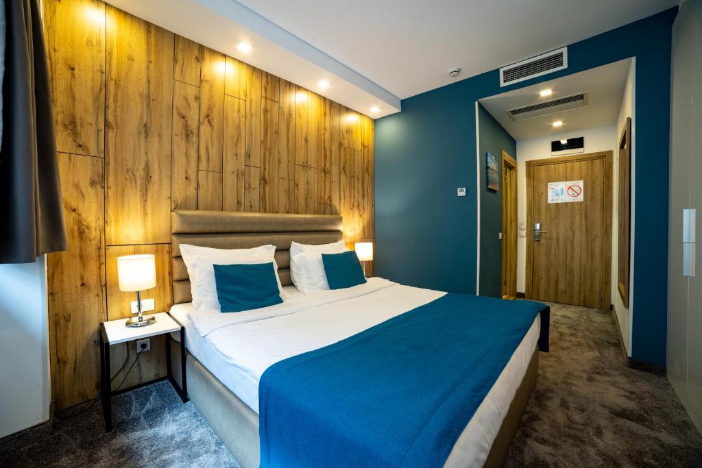 1 dormitorio con cama y pared azul en MARK Hotel en Belgrado