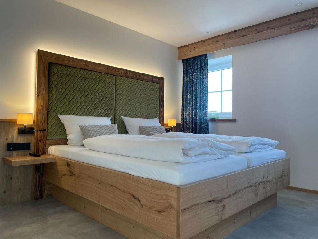 Schlafzimmer mit einem großen Bett mit einem Kopfteil aus Holz in der Unterkunft Hotel Gasthof zum Wulfen in Sulzbach-Rosenberg