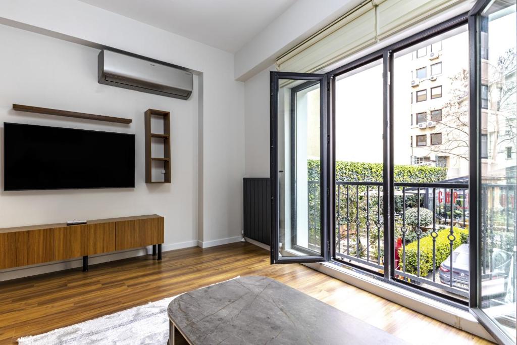 een woonkamer met een groot raam en een flatscreen-tv bij Central and Modernly Furnished Flat in Sisli in Istanbul