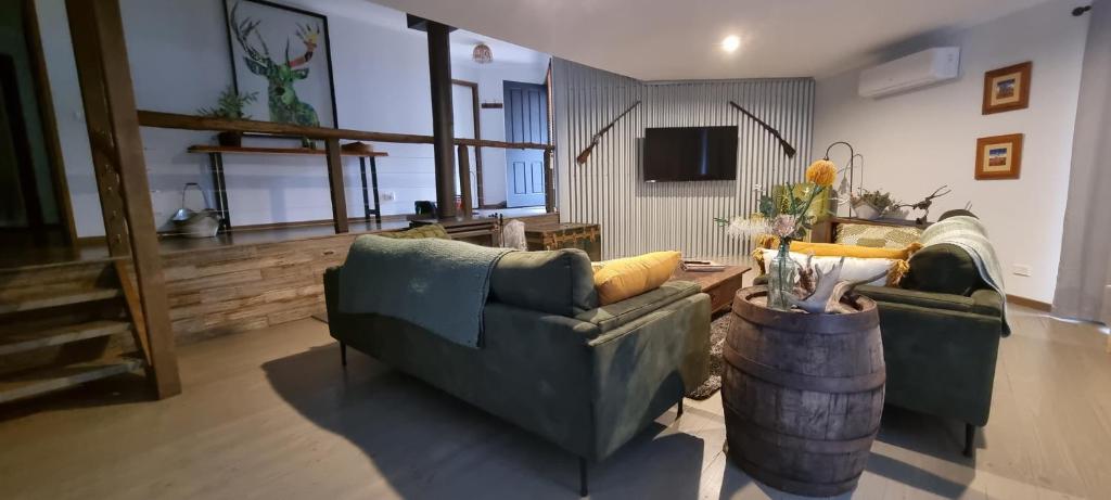 a living room with two couches and a tv at Wally's Edge 20acre Farm Stay in Rawson