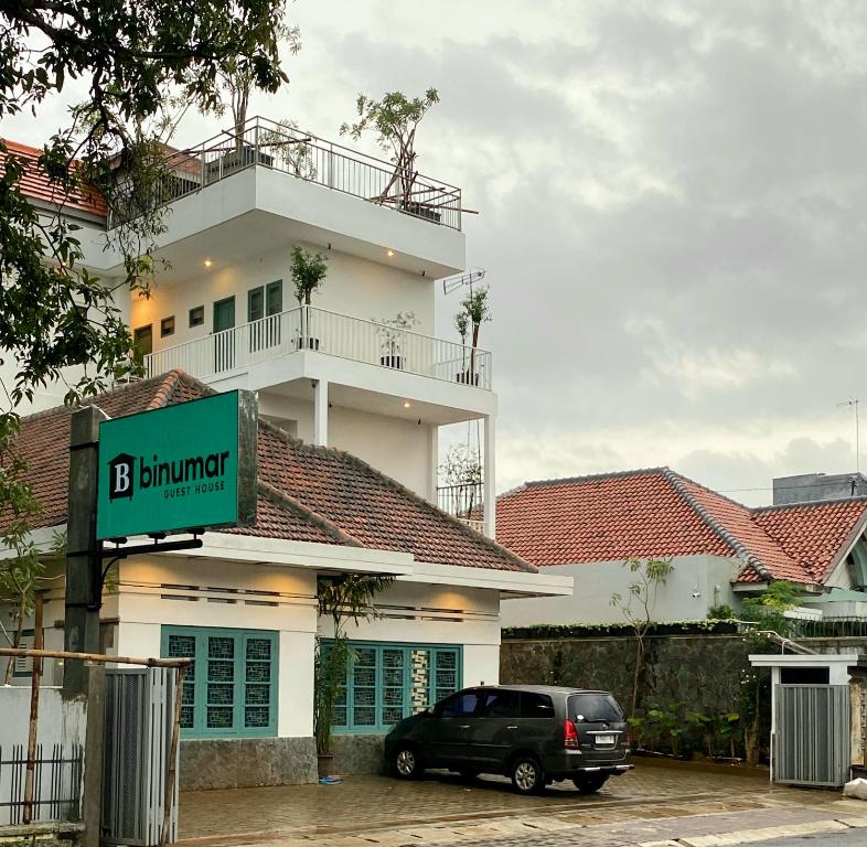 a black car parked in front of a building at BINUMAR GUEST HOUSE PEKALONGAN in Pekalongan