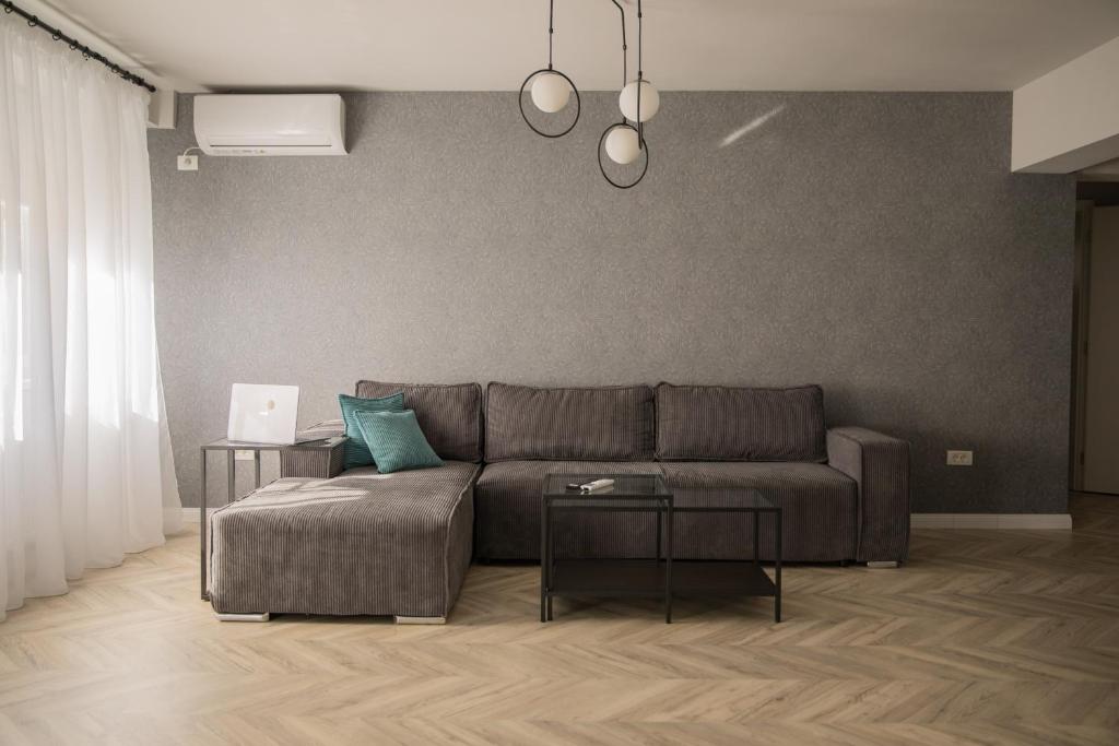 a living room with a couch and two tables at Sabrini Residence B3 Timisoara Old Town in Timişoara
