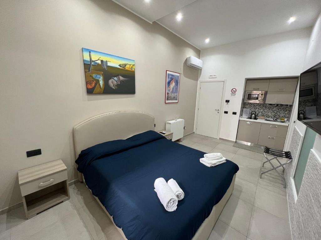 um quarto com uma cama azul com toalhas em Room25mq em Cercola