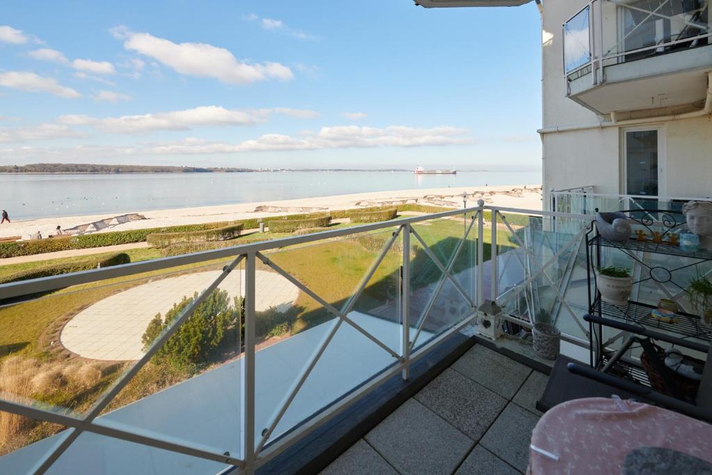 balcón con vistas a la playa y al agua en Strandhotel 14, en Laboe