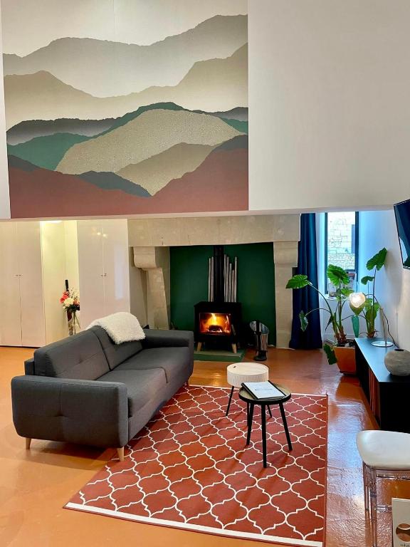 un salon avec un canapé et une cheminée dans l'établissement La Maison BellecOur, à Vaudelnay
