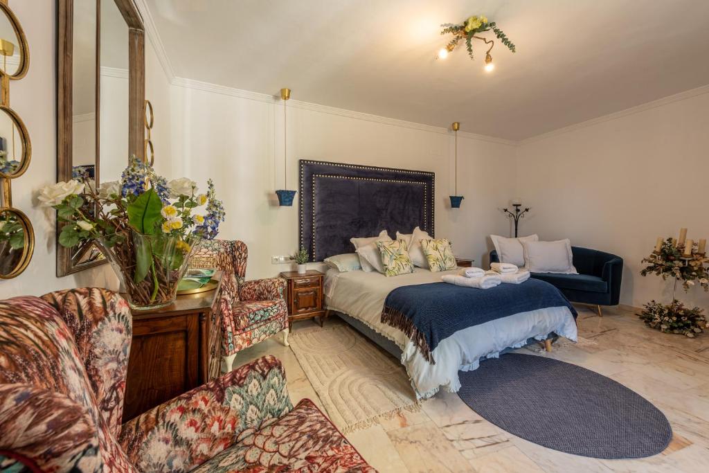 a bedroom with a bed and a couch and a chair at La Casona Verde in Almodóvar del Río