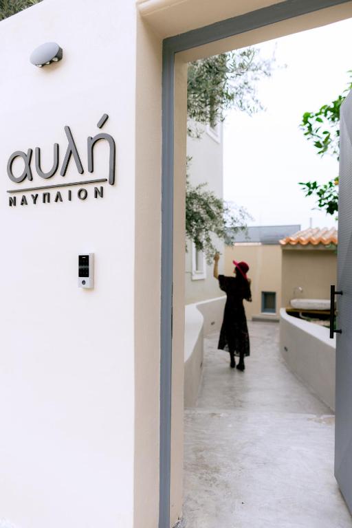 a woman is standing outside of a building at αυλή Ναύπλιον in Nafplio