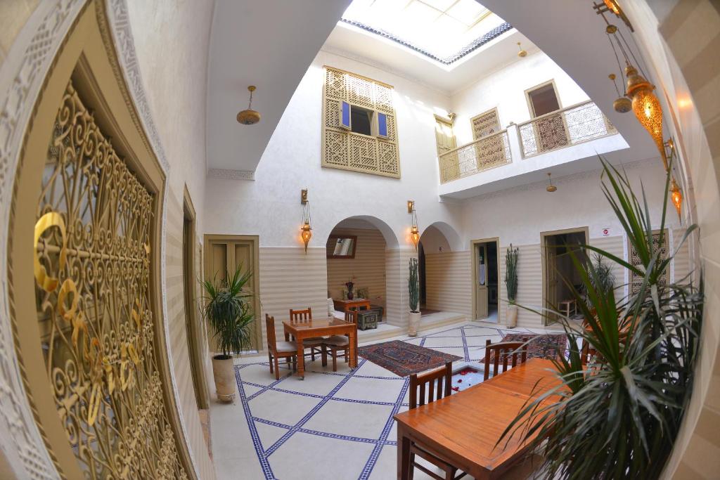 Riad Marana Hotel & Spa في مراكش: مدخل منزل به طاولة وكراسي