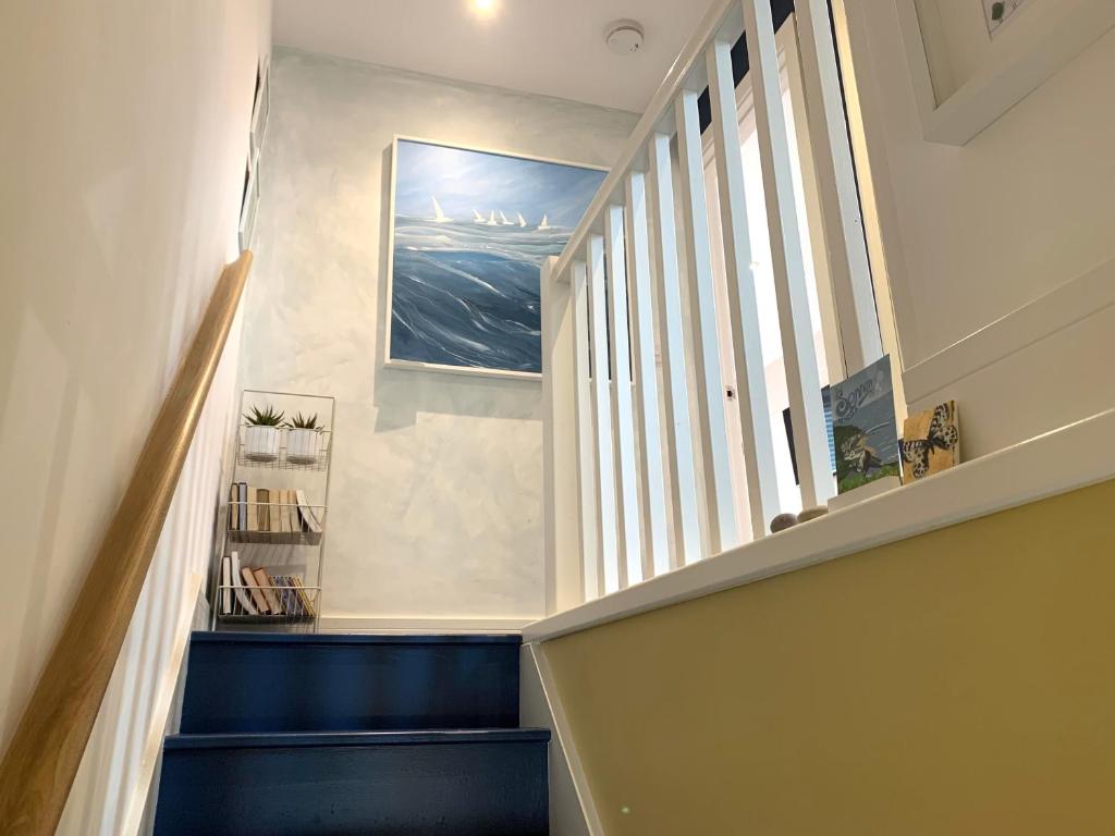 a stairway with blue steps and a window at The Seawitch - harbourside apartment in Mousehole