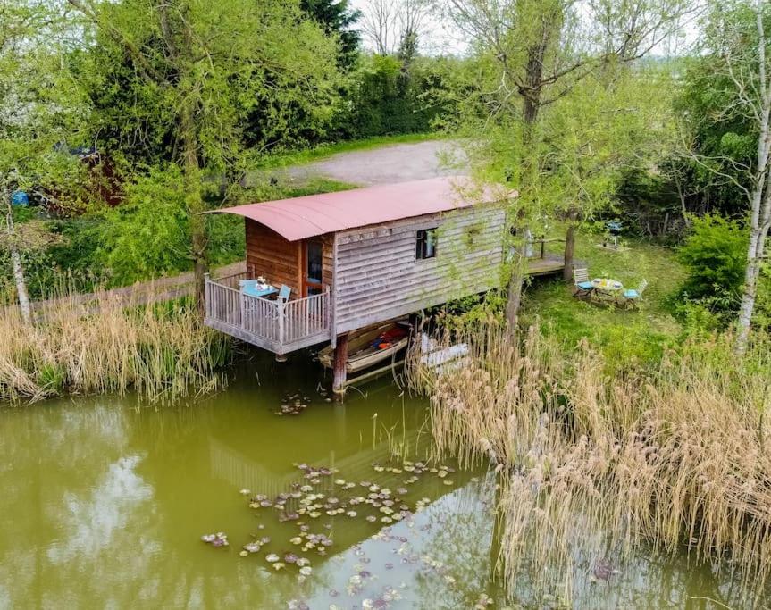 a log cabin in the middle of a lake at Lakeside Cabin on Stilts- 'Kingfisher' in Rous Lench