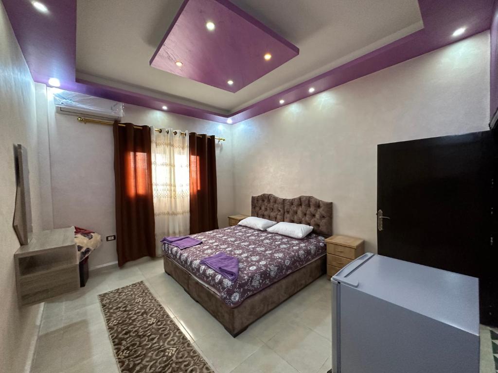 a bedroom with a bed and a flat screen tv at Petra View Flat in Wadi Musa