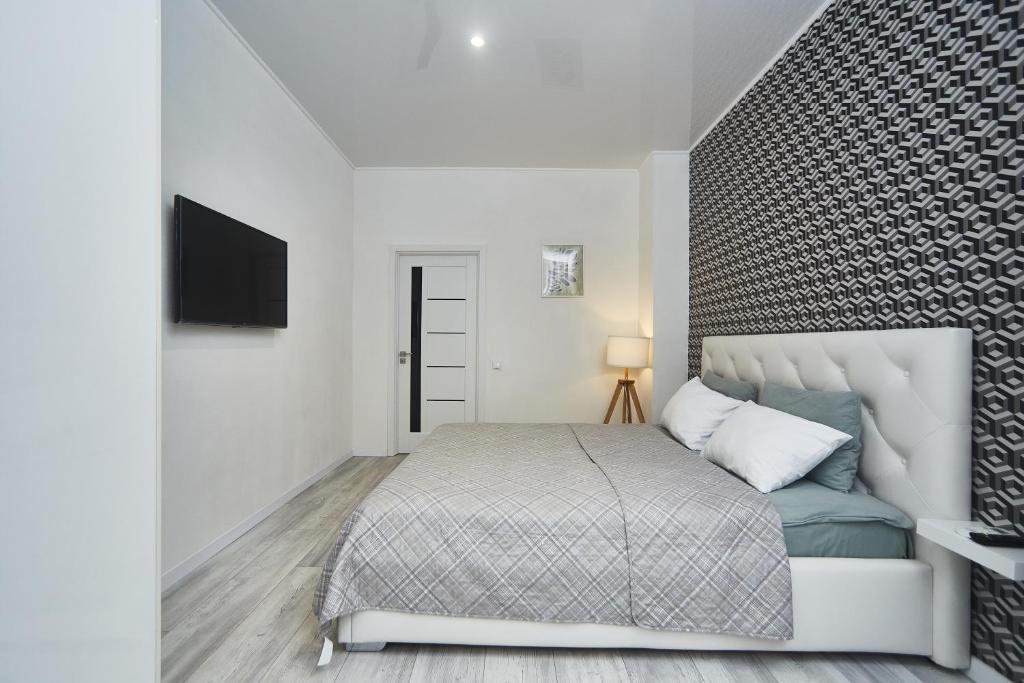 um quarto com uma cama e uma televisão na parede em Apartments Club Marine em Odessa