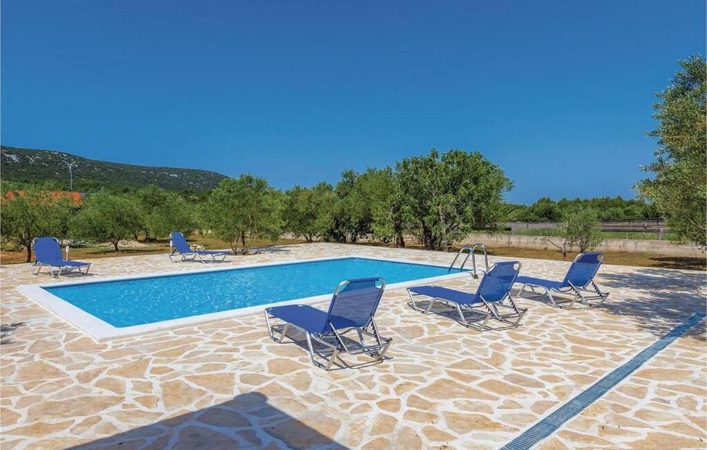a swimming pool with blue chairs and a swimming pool at House Hacienda in Tribunj