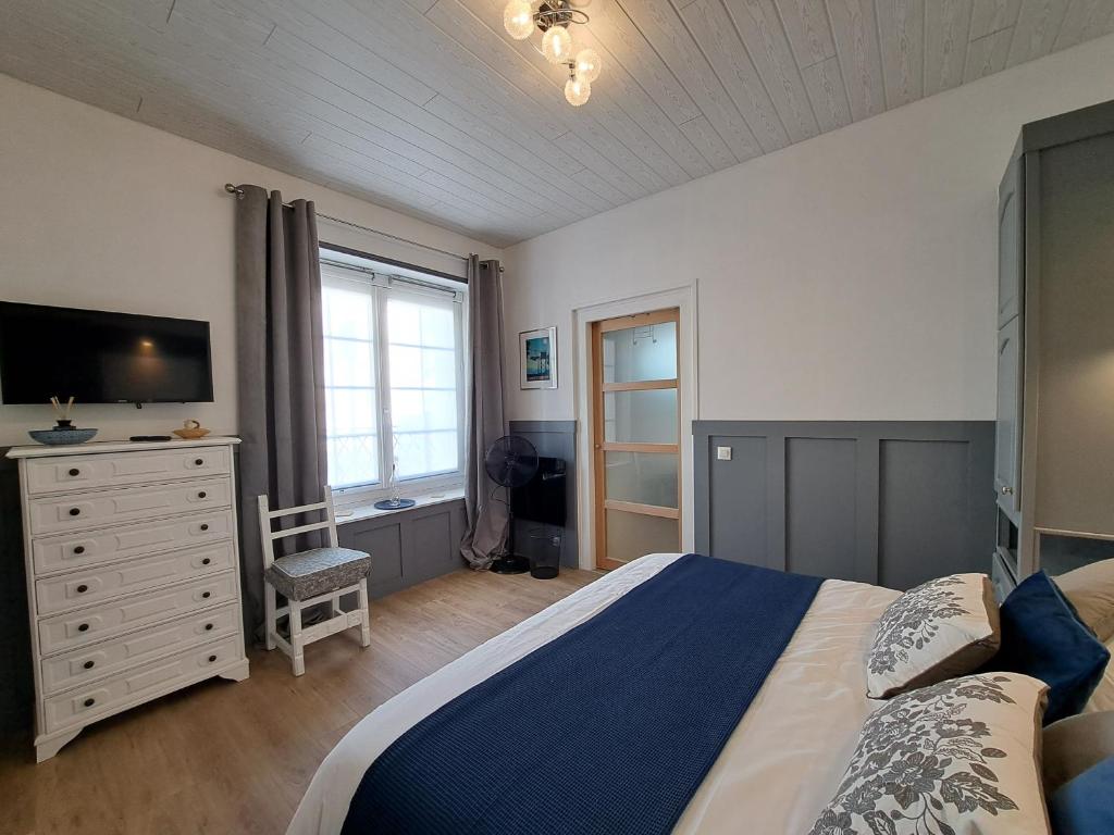 - une chambre avec un lit et une commode avec une télévision dans l'établissement Villa des Thermes, St Jean d'Angély, à Saint-Jean-dʼAngély