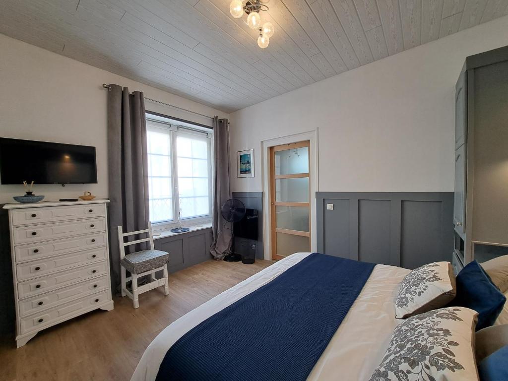 een slaapkamer met een bed en een dressoir met een televisie bij Villa des Thermes, St Jean d'Angély in Saint-Jean-dʼAngély