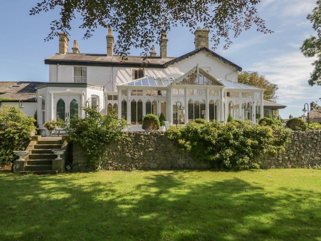 a large white house with a stone wall at Valley View in Dalton in Furness