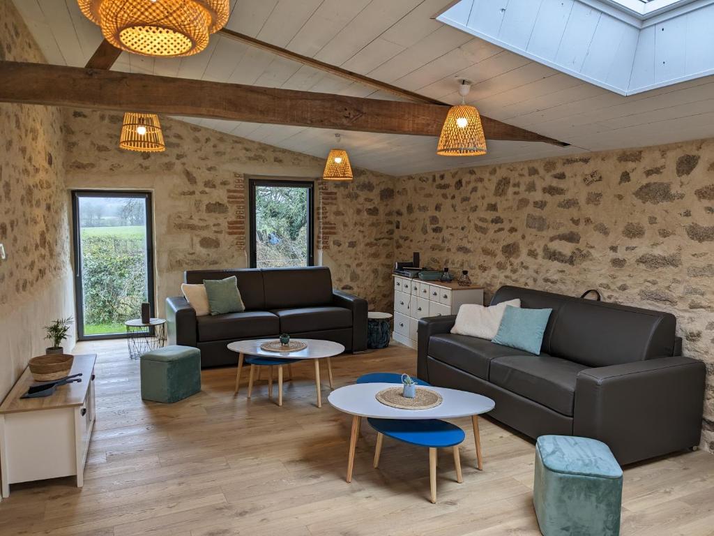 a living room with two couches and two tables at Maison de Vacances 12min du Puy du fou grand studio in Saint-Laurent-sur-Sèvre