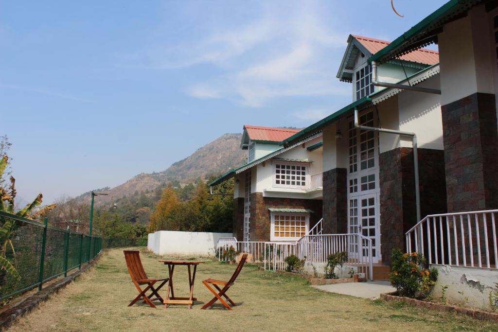 ein Haus mit zwei Stühlen und einem Tisch im Hof in der Unterkunft Brown Stone Villa in Bhīm Tāl