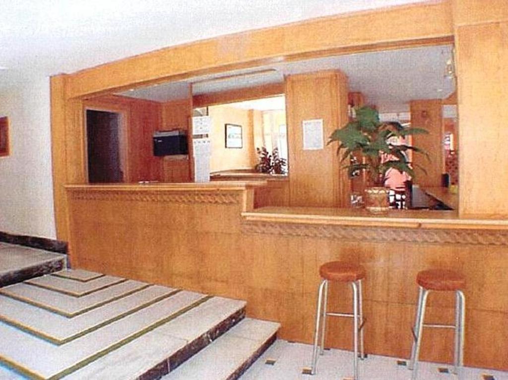 um bar com dois bancos e um espelho em Hotel Iris em Benidorm