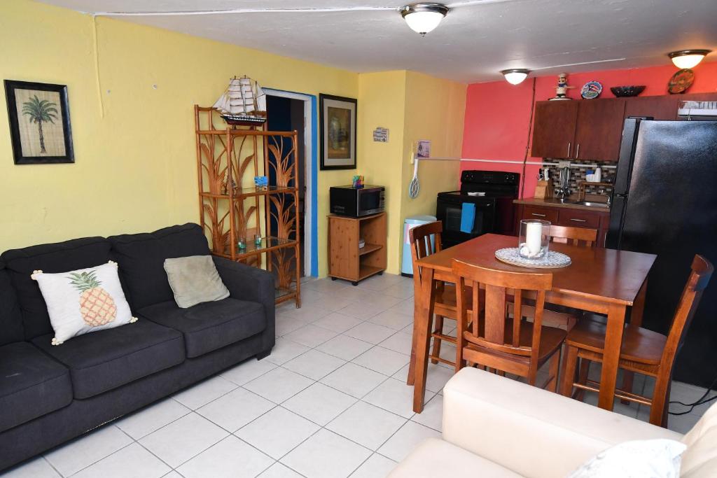 sala de estar con sofá, mesa y cocina en Coqui del Mar - LGBTQ Hotel - Adults Only, en San Juan