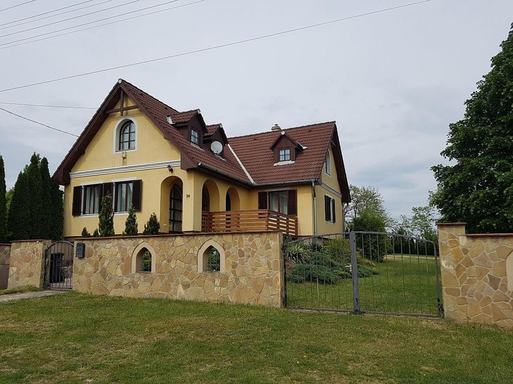 duży żółty dom z brązowym dachem w obiekcie Márkói Vendégház 