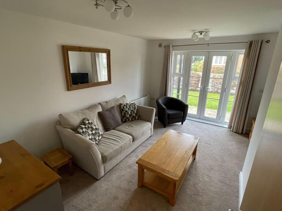 ein Wohnzimmer mit einem Sofa und einem Tisch in der Unterkunft 2 Bedroom Ground Floor Flat in Haddenham