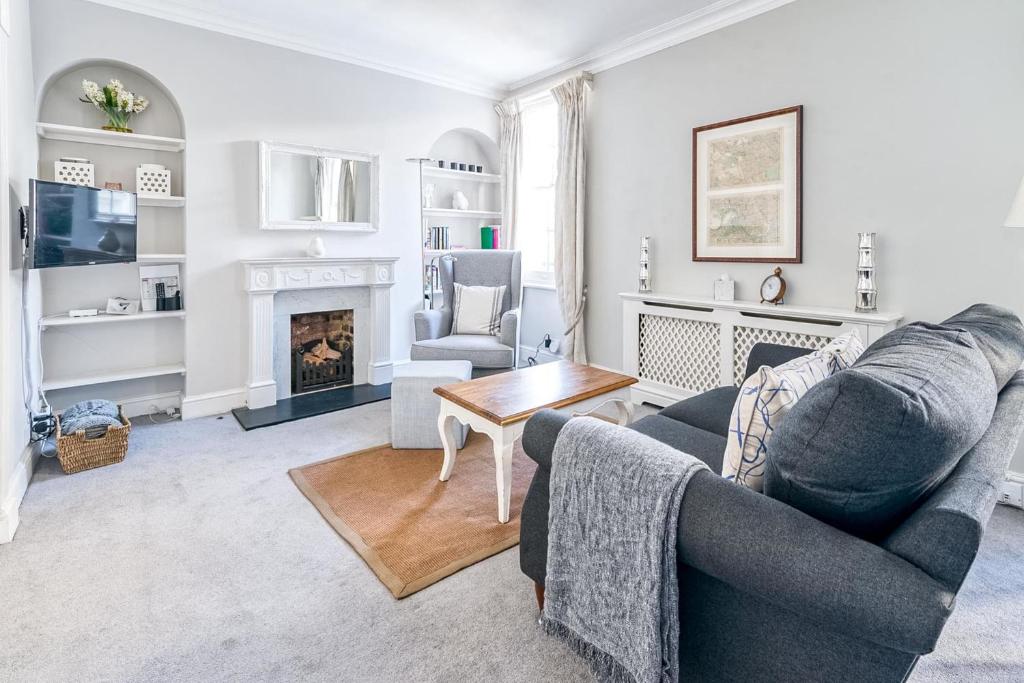 a living room with a couch and a fireplace at Cozy and Spacious Kensington Maisonette in London