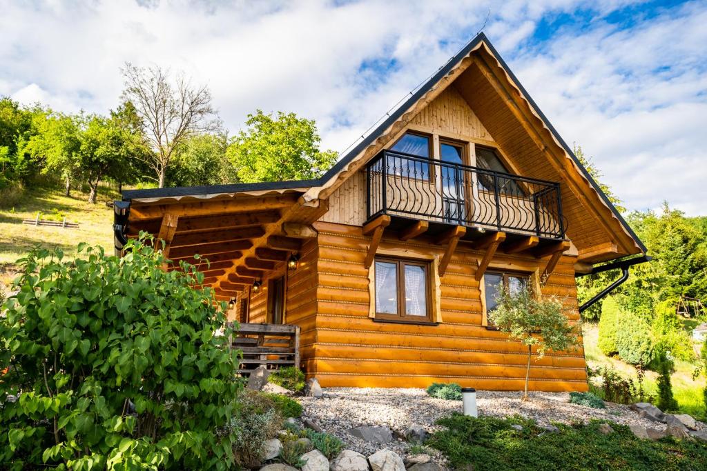a log cabin with a balcony on top of it at Chata pod kopcom in Žarnovica