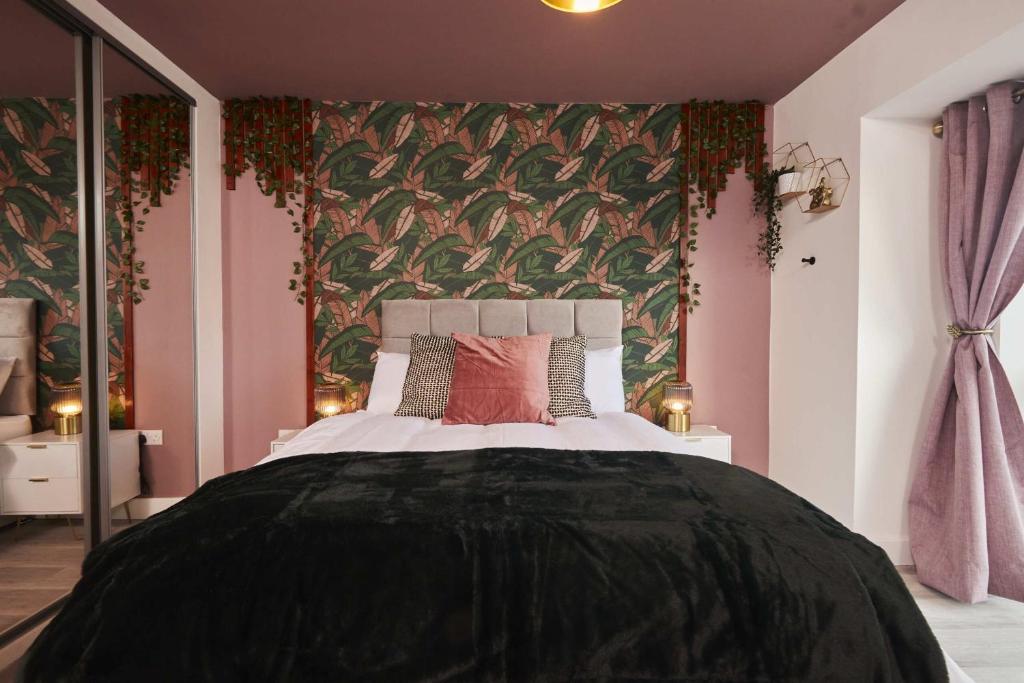 a bedroom with a large bed with a green and pink wall at Homebird Property - The Willows in Leeds