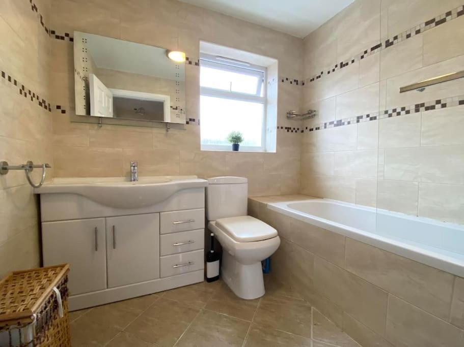 a bathroom with a sink and a toilet and a bath tub at Family Relax in the Seaside Town with Parking in Hastings