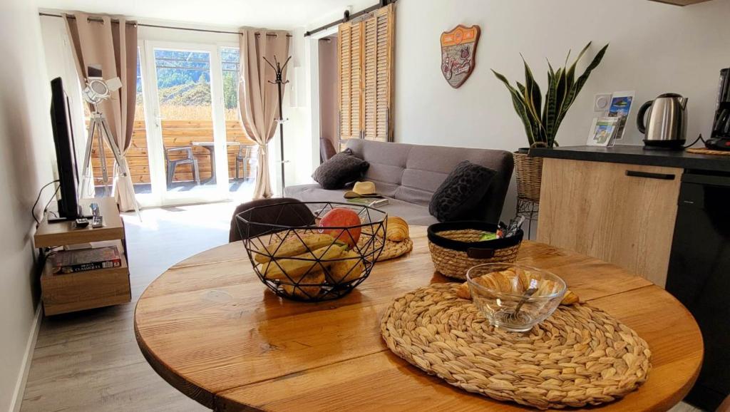 a living room with a wooden table with baskets on it at Entre Ciel et Verdon in Castellane