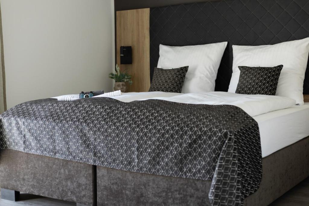 a large bed with a black and white comforter at Kadir Bey & Four Rooms in Osterrönfeld