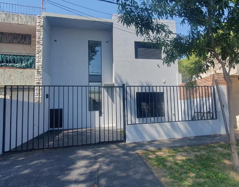 una puerta frente a una casa blanca en Casa en La Florida a metros río en Rosario