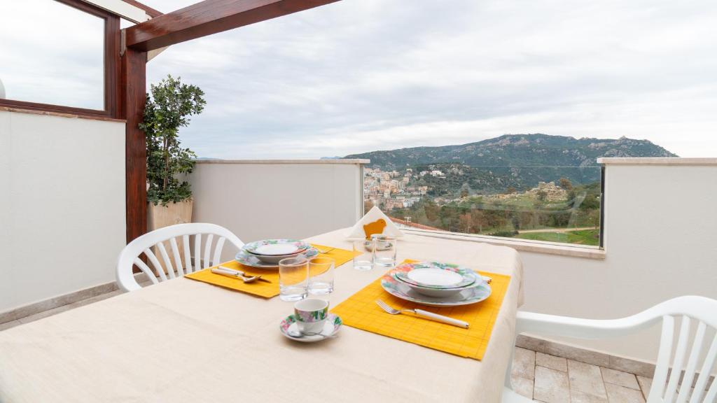 comedor con mesa y vistas a las montañas en Welcomely - Appartamento Nuraghe Tanca Manna, en Nuoro