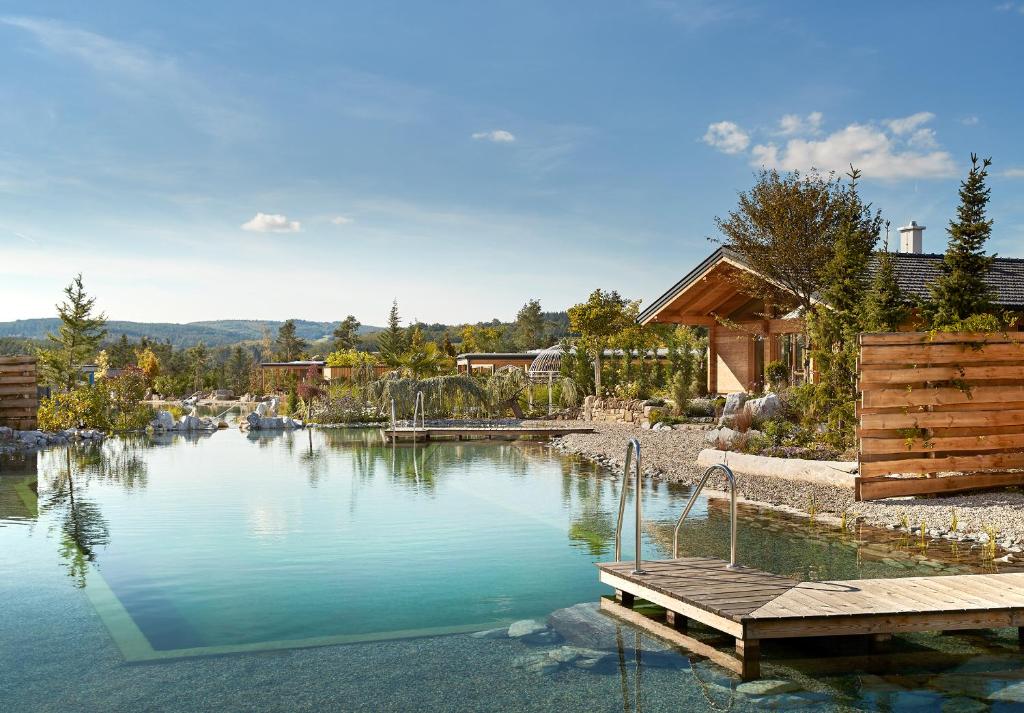 a large pool of water with a wooden dock at Kittenberger Chalets am Gartensee in Schiltern